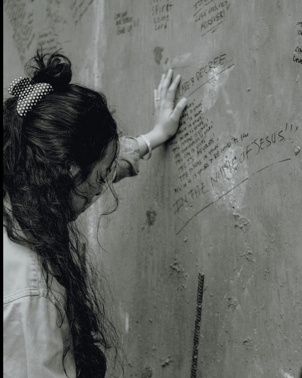 A hand pressed against the dedication wall