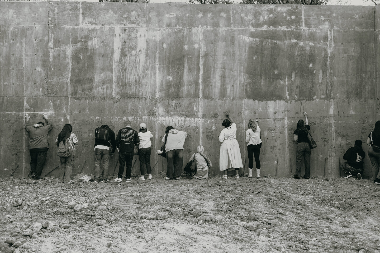 People writing prayers on the concrete walls of The Justice Residence